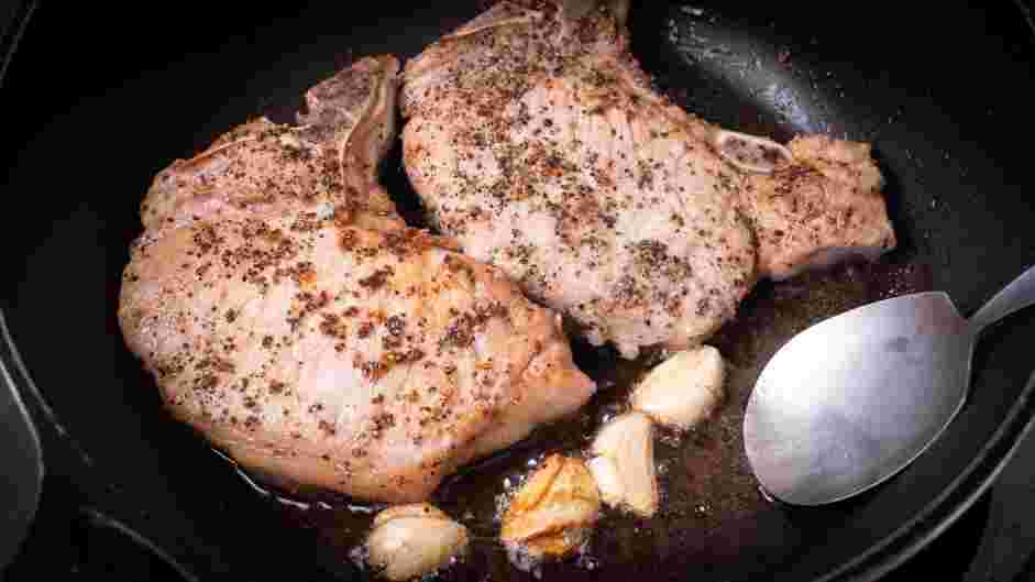 Skillet Pork Chops Recipe:
Remove the skillet from the oven and add garlic cloves.