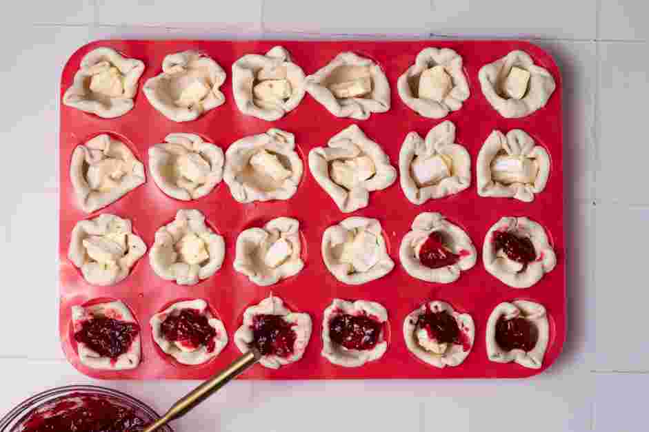 Cranberry Brie Bites Recipe: Top the brie with one teaspoon of cranberry sauce.