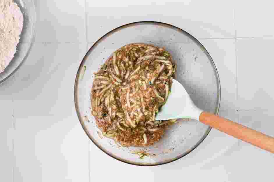 Vegan Zucchini Bread Recipe: In a medium mixing bowl, combine the applesauce, maple syrup, brown sugar, vanilla extract, grated zucchini and the flax egg together.