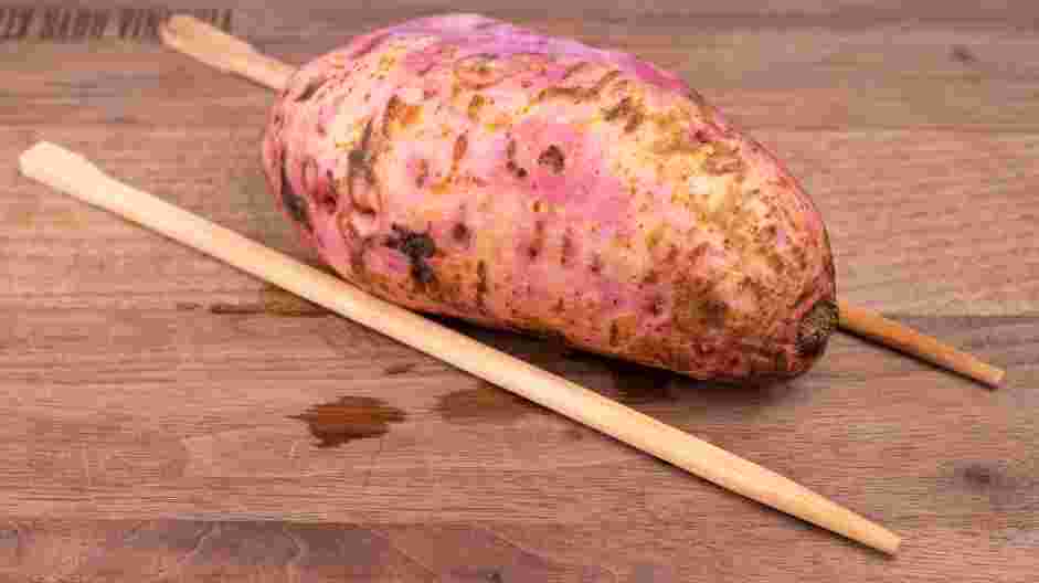 Hassleback Sweet Potatoes Recipe: Place the sweet potato, cut-side down, between two wooden chopsticks.