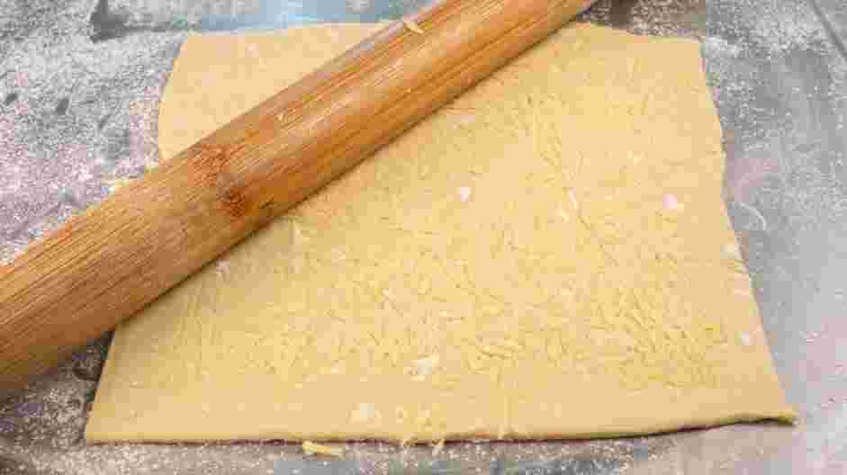 Mummy Dogs Recipe: Adhere the cheddar cheese to the puff pastry by rolling out the puff pastry lightly with a rolling pin.