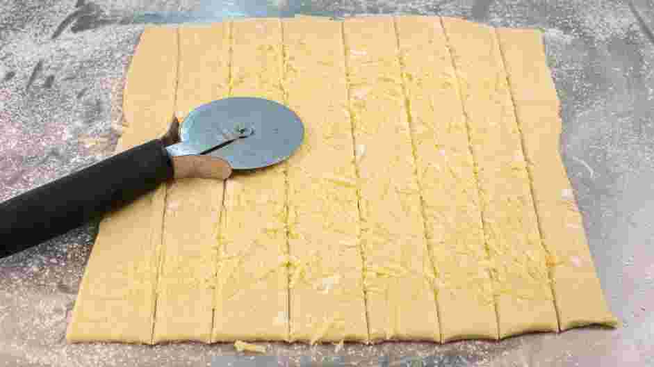 Mummy Dogs Recipe: Use a sharp knife or a pizza cutter to cut the pastries into ten strips.