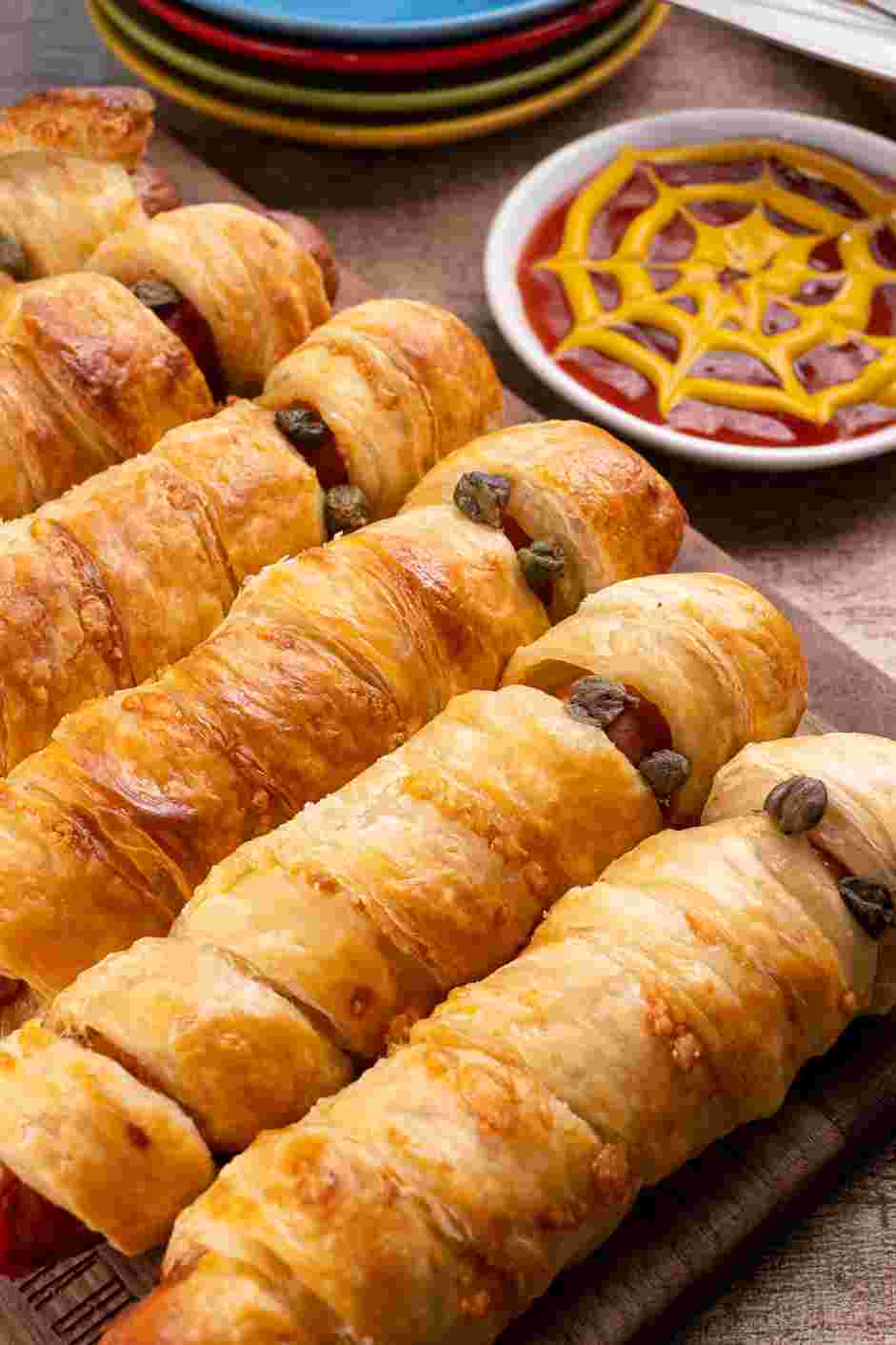 Mummy Dogs Recipe:
If using the candy eyes, ketchup or mustard for the eyes, adhere the candy eyes or draw two dots for eyes with the ketchup or mustard before serving.