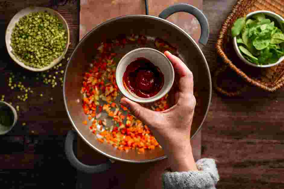 Vegan Lentil Soup Recipe: Add the tomato paste, ginger, coriander, crushed red pepper, cumin and turmeric and saut&eacute; for 1 minute.