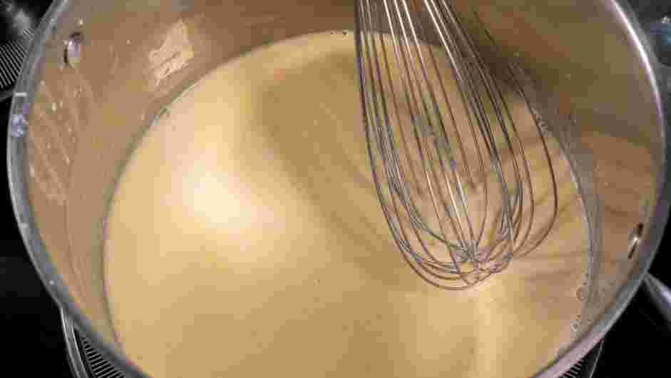 Besciamella Recipe: Turn off the heat and add the heated milk one ladle at a time, while constantly whisking.