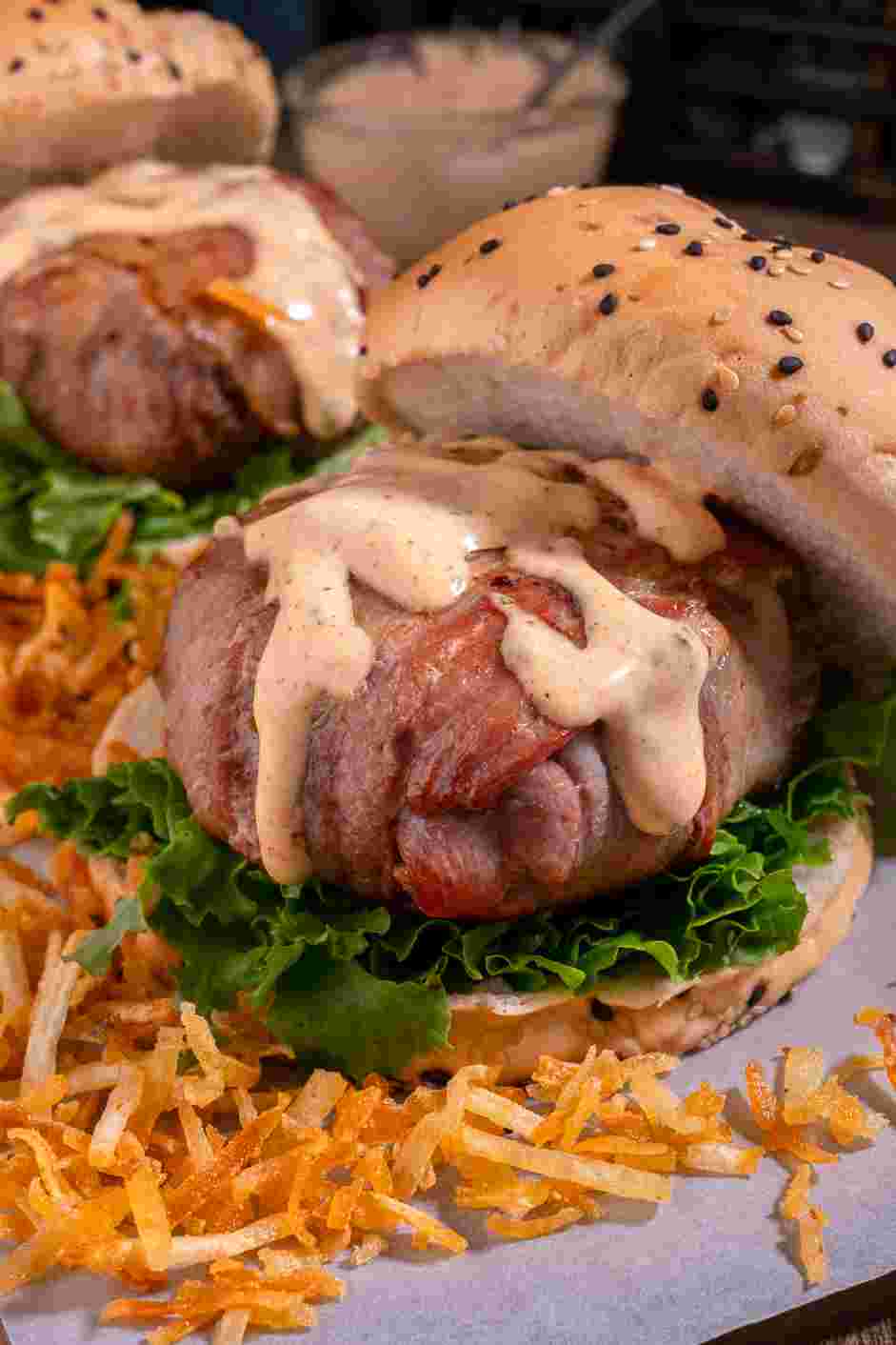 Bacon Wrapped Burger Recipe: Serve patties on burger buns with the creole drizzle and your favorite condiments.