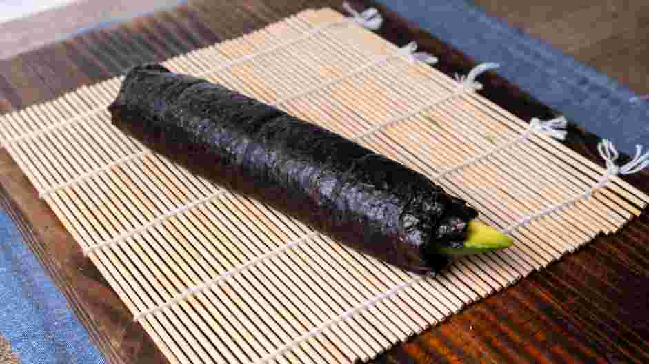 Avocado Roll Recipe: Lift one edge of the sushi mat and tightly roll up to the other end.