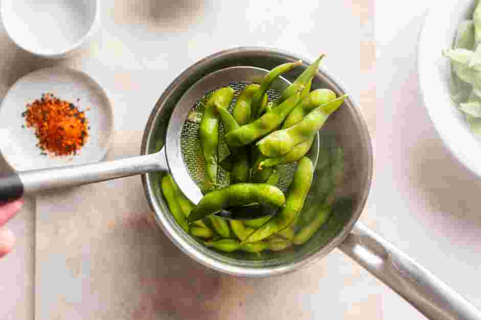 Spicy Edamame Recipe:
Cook edamame pods for 3-5 minutes and drain.