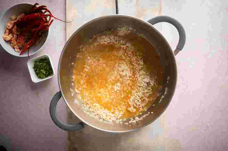 Lobster Risotto Recipe: Pour in one cup of the fish stock and stir until it is absorbed into the rice.