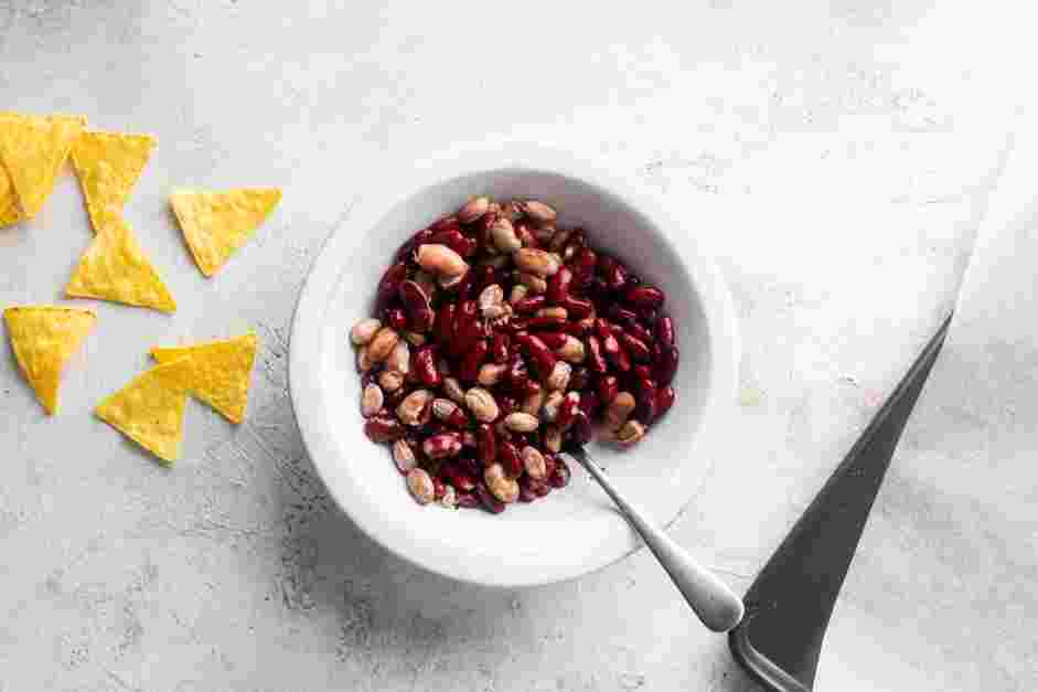 Sheet Pan Nachos Recipe: In a small bowl, combine the kidney beans and the refried beans.