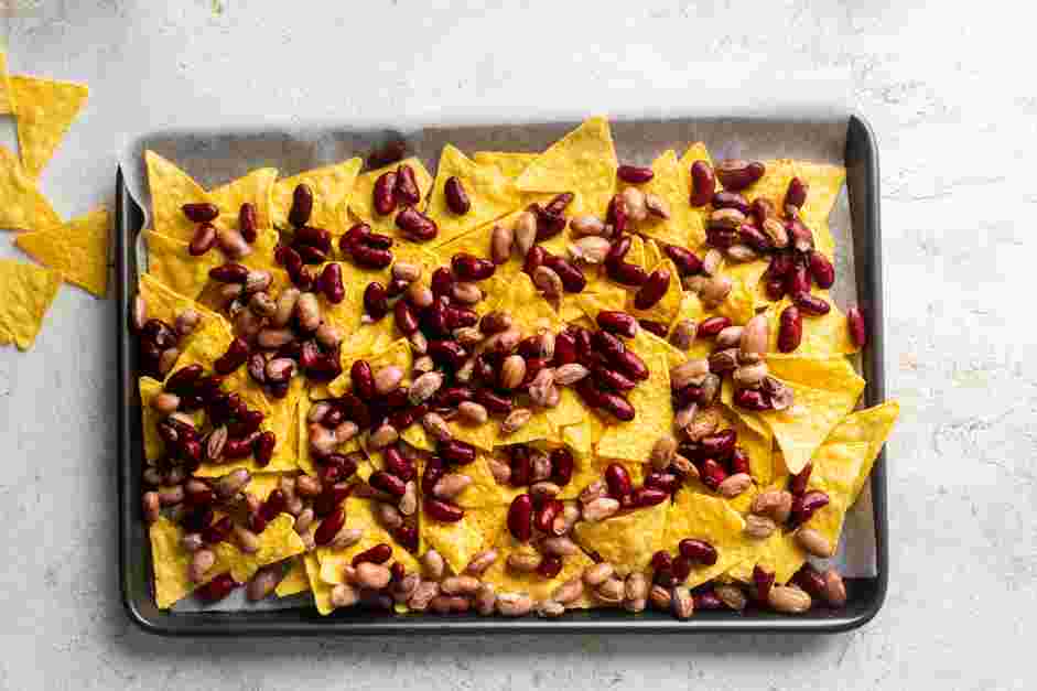 Sheet Pan Nachos Recipe:
Use a spoon to spread the bean mixture over the chips.