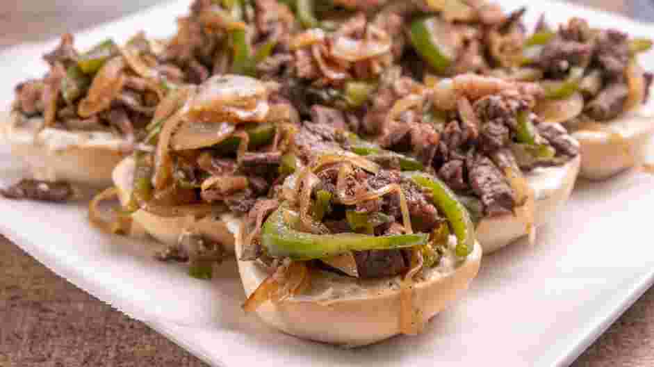 Philly Cheesesteak Sliders Recipe: Evenly spread the steak mixture over the rolls.