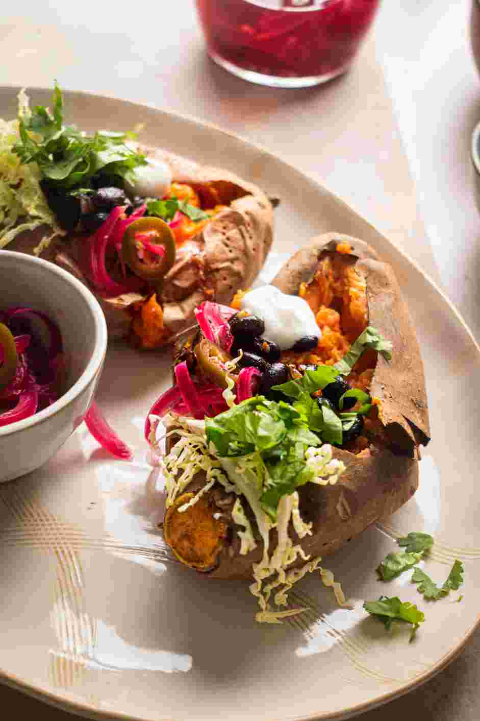 Stuffed Sweet Potatoes Recipe: 
Evenly spread the black bean mixture between the potatoes, top with the shredded cabbage or lettuce and pickled red onions and jalape&ntilde;os.