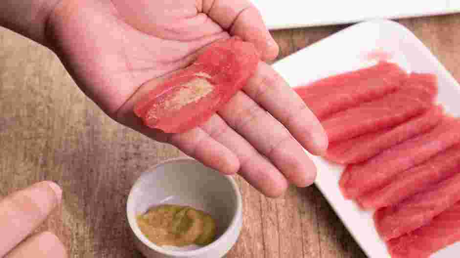 Easy Tuna Nigiri Recipe: 
Place the thinly sliced fish in your hand at the base of your fingers and add a small dab of wasabi to the center of the fish.