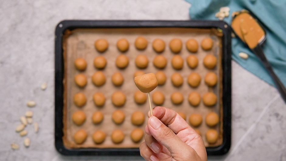 Buckeye Cookies Recipe: Use a toothpick to poke a peanut butter ball.