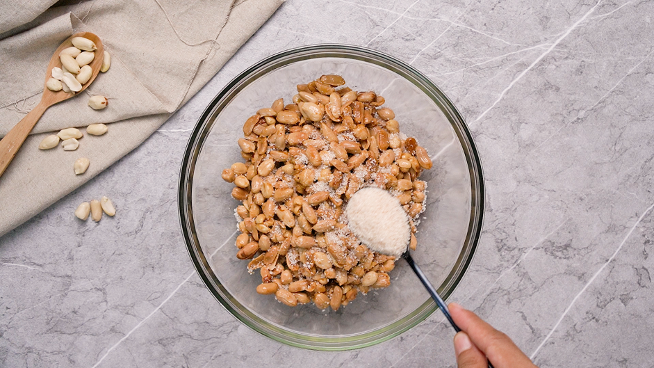 Honey Roasted Peanuts Recipe: Add the sugar mixture to the peanuts by the spoonful while constantly stirring to keep the peanuts from sticking to each other.