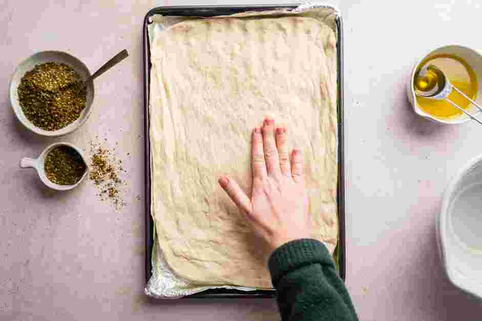 Zaatar Bread Recipe: 
Evenly stretch the dough out to the edges of the baking sheet with your hands.