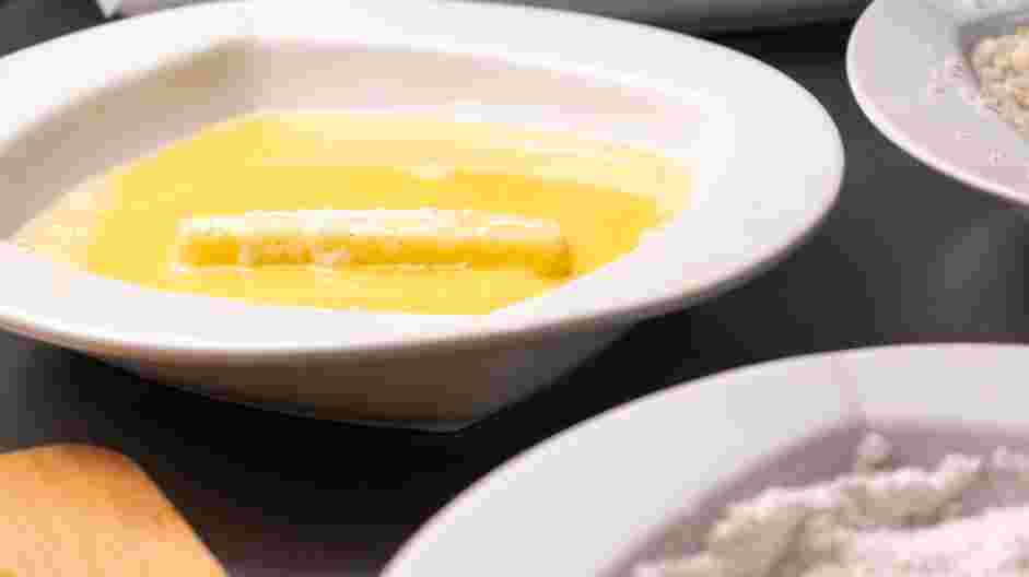 Air Fryer Mozzarella Sticks Recipe:
Coat the floured string cheese in the egg mixture and let the excess drip off.