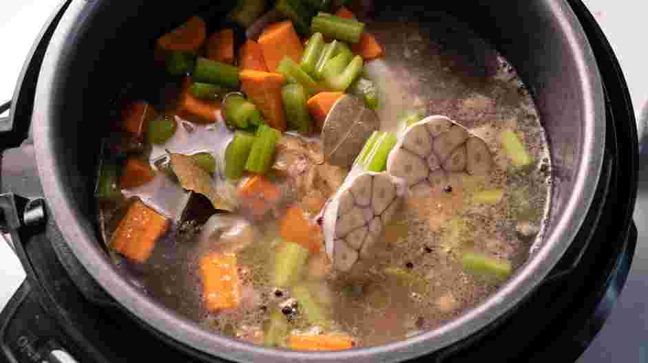 Instant Pot Bone Broth Recipe: Return the bones to the pot and add the onion, garlic, celery, carrots, bay leaf, peppercorns, apple cider vinegar and the remaining seven cups of water.
