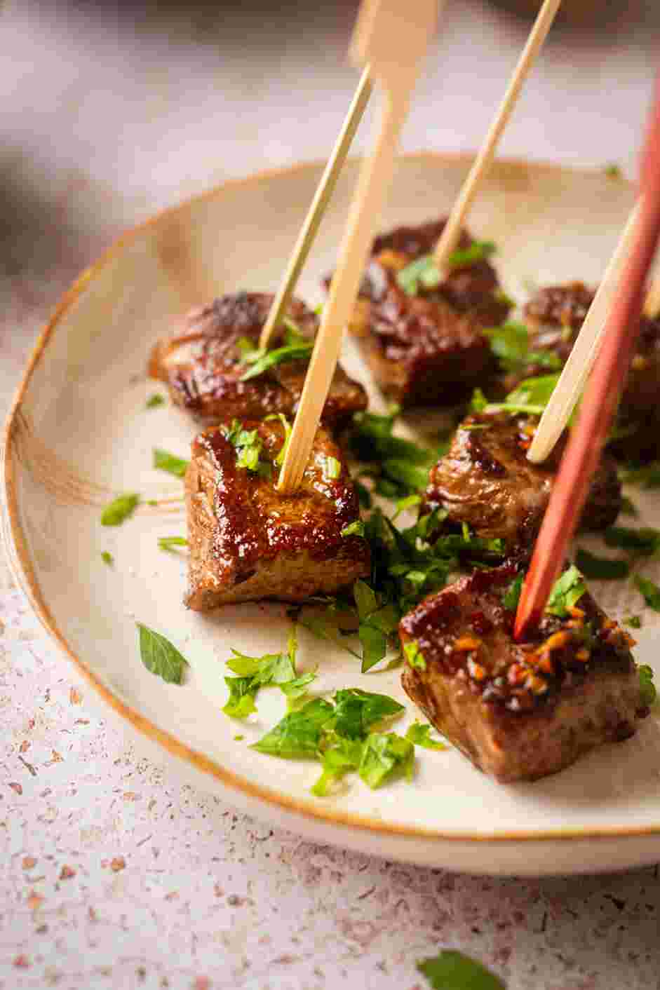 Garlic Butter Steak Bites Recipe: Skewer the steaks onto decorative toothpicks, sprinkle with parsley and serve warm.