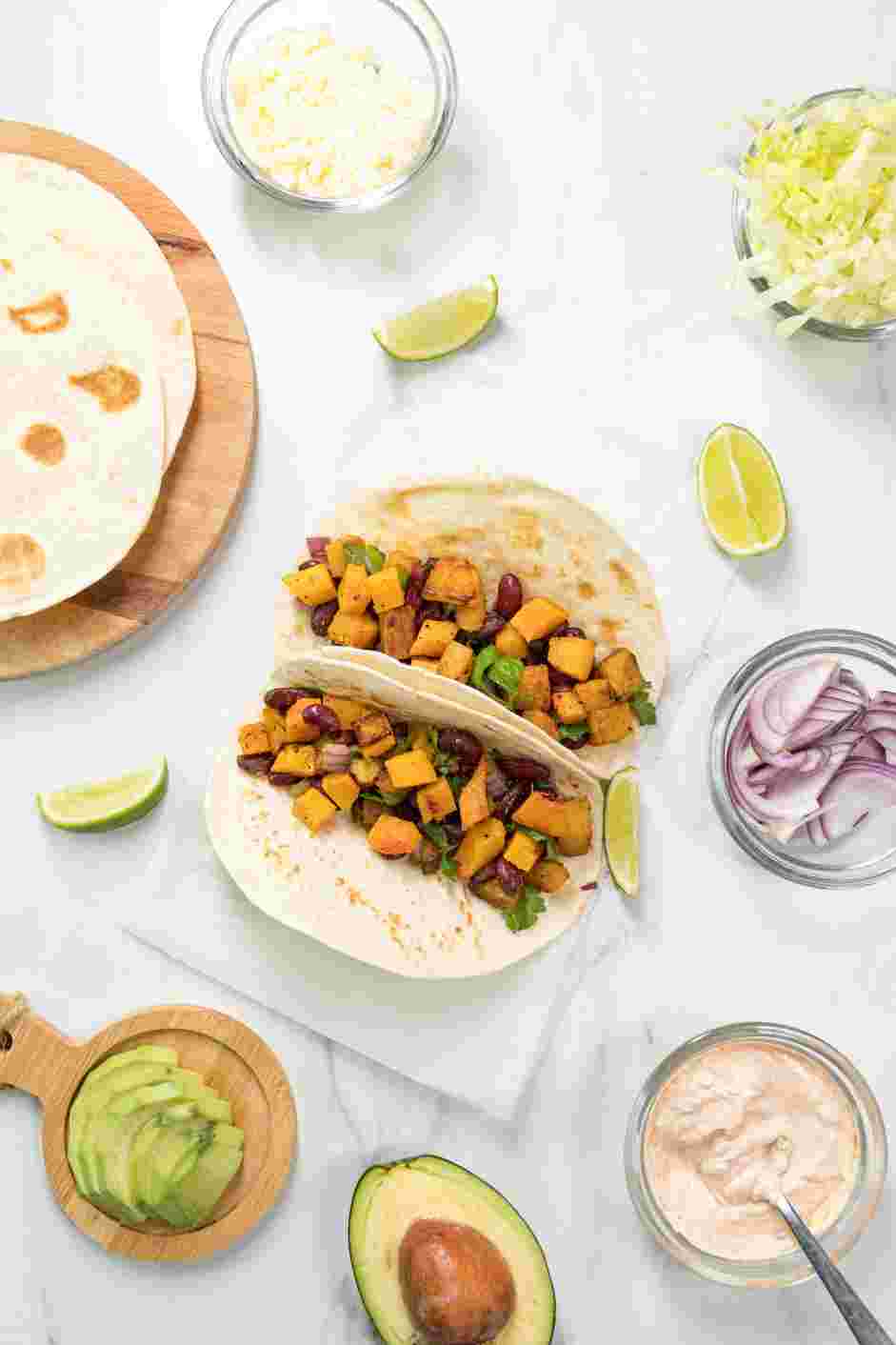 Butternut Squash Tacos Recipe:
For serving, put the lettuce, extra chopped onion, feta, avocado, chili-lime crema and lime wedges on a platter.