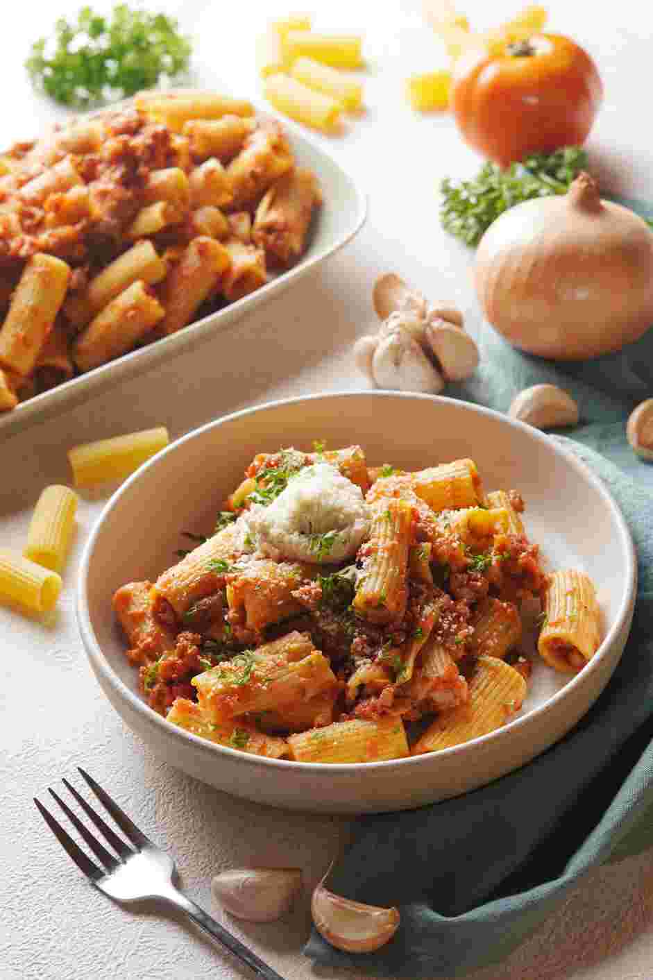 Rigatoni Bolognese Recipe: Plate the pasta and add a dollop of ricotta, freshly grated Parmesan cheese and a sprinkling of chopped parsley.