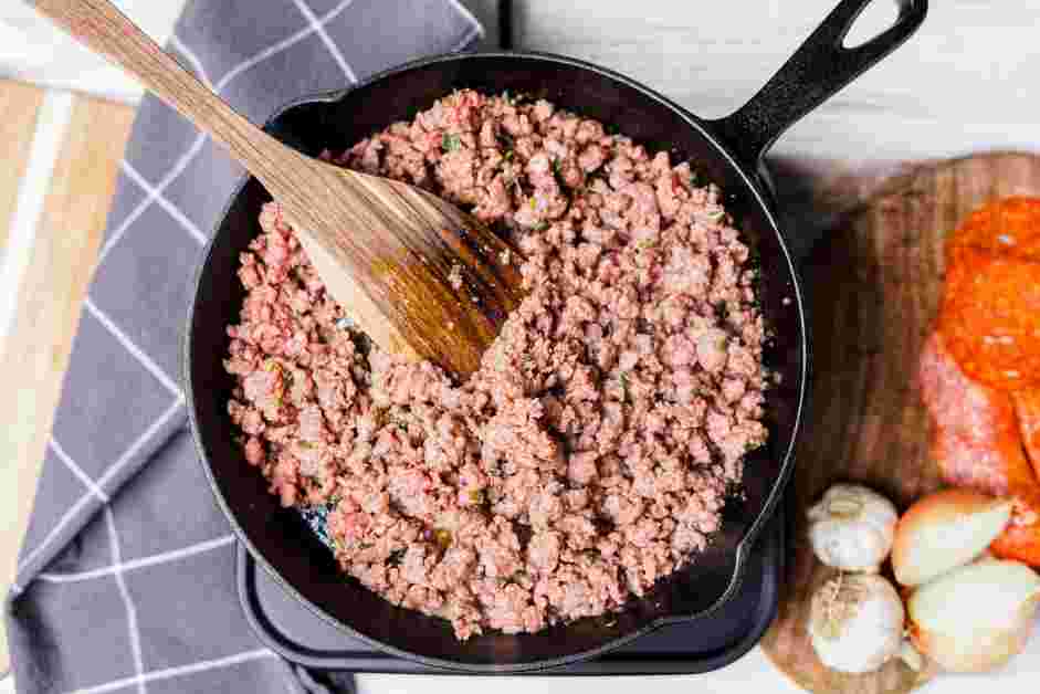 Crustless Pizza Recipe: In a large cast-iron skillet, add the sausage and cook until browned, about 4-6 minutes.