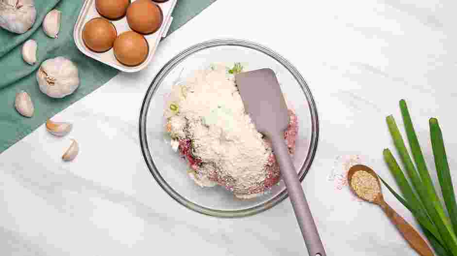 Spicy Meatball Recipe: Add the gochujang, sliced scallions, grated garlic, grated ginger, grated Korean radish, beaten egg, dry milk powder and bread crumbs into the bowl.