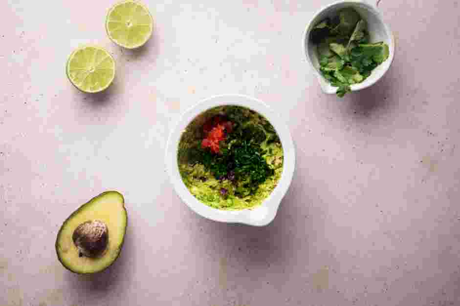 Keto Guacamole Recipe: Fold in the minced Roma tomato, chopped cilantro, minced jalapeno and minced red onion with a spatula.