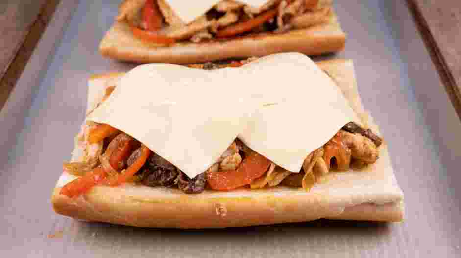 Chicken Cheesesteak Recipe: Place the chicken cheesesteak filling evenly on each roll and place two slices of provolone cheese on top of each roll.