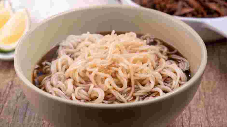 Birria Ramen Recipe: Drain the noodles and divide the cooked noodles into two bowls.