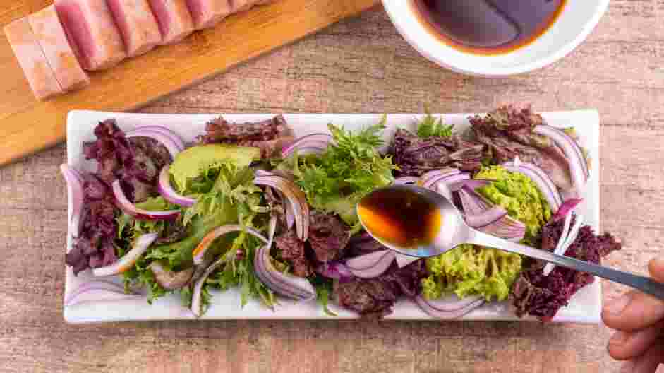 Tuna Tataki Recipe: Use a spoon to dress the greens and red onion by drizzling it with ponzu sauce.