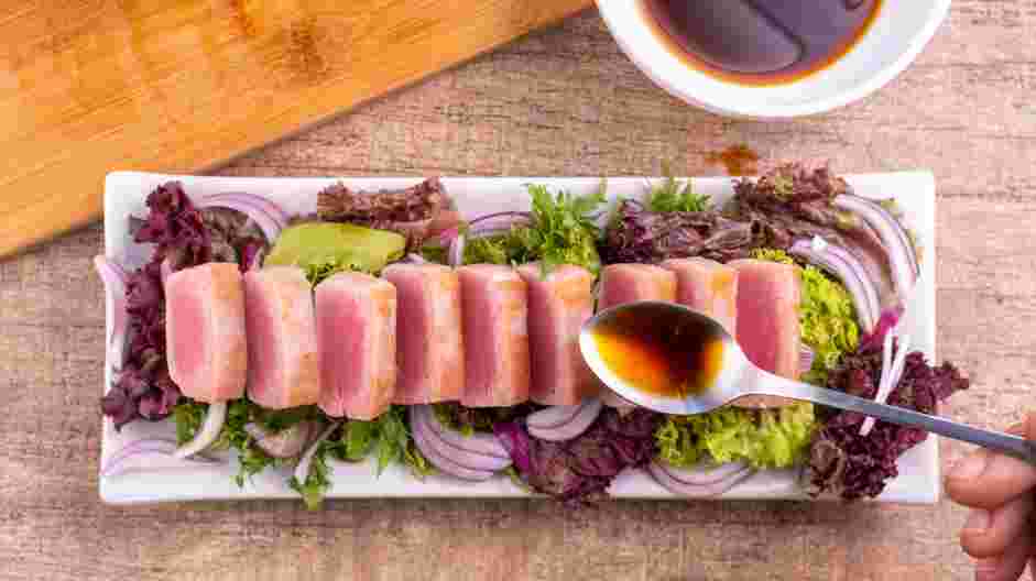 Tuna Tataki Recipe:
Neatly arrange the seared and sliced tuna in a straight, overlapped line on top of the red onions.