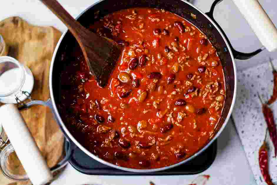 Red Chili Recipe: Sitr in the unsalted beef stock, tomato paste, diced tomatoes, undrained red beans, undrained pinto beans, Spanish paprika, chili powder, cayenne pepper, ground cumin, onion powder and brown sugar.