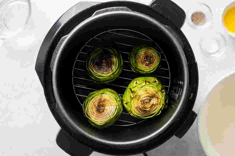 Instant Pot Artichokes Recipe: Place the trimmed artichokes on top of the steaming rack and close the lid.