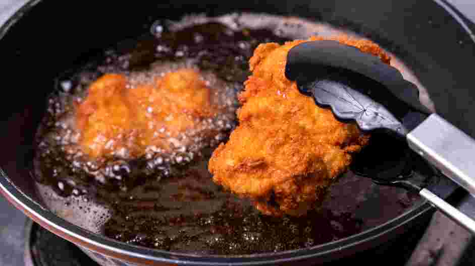 Honey Fried Chicken Recipe: Once the oil is heated, drop each of the dredged chicken thighs into the hot oil.