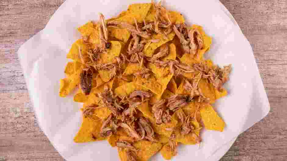 Pulled Pork Nachos Recipe: Evenly spread half of the pulled pork over the tortilla chips.