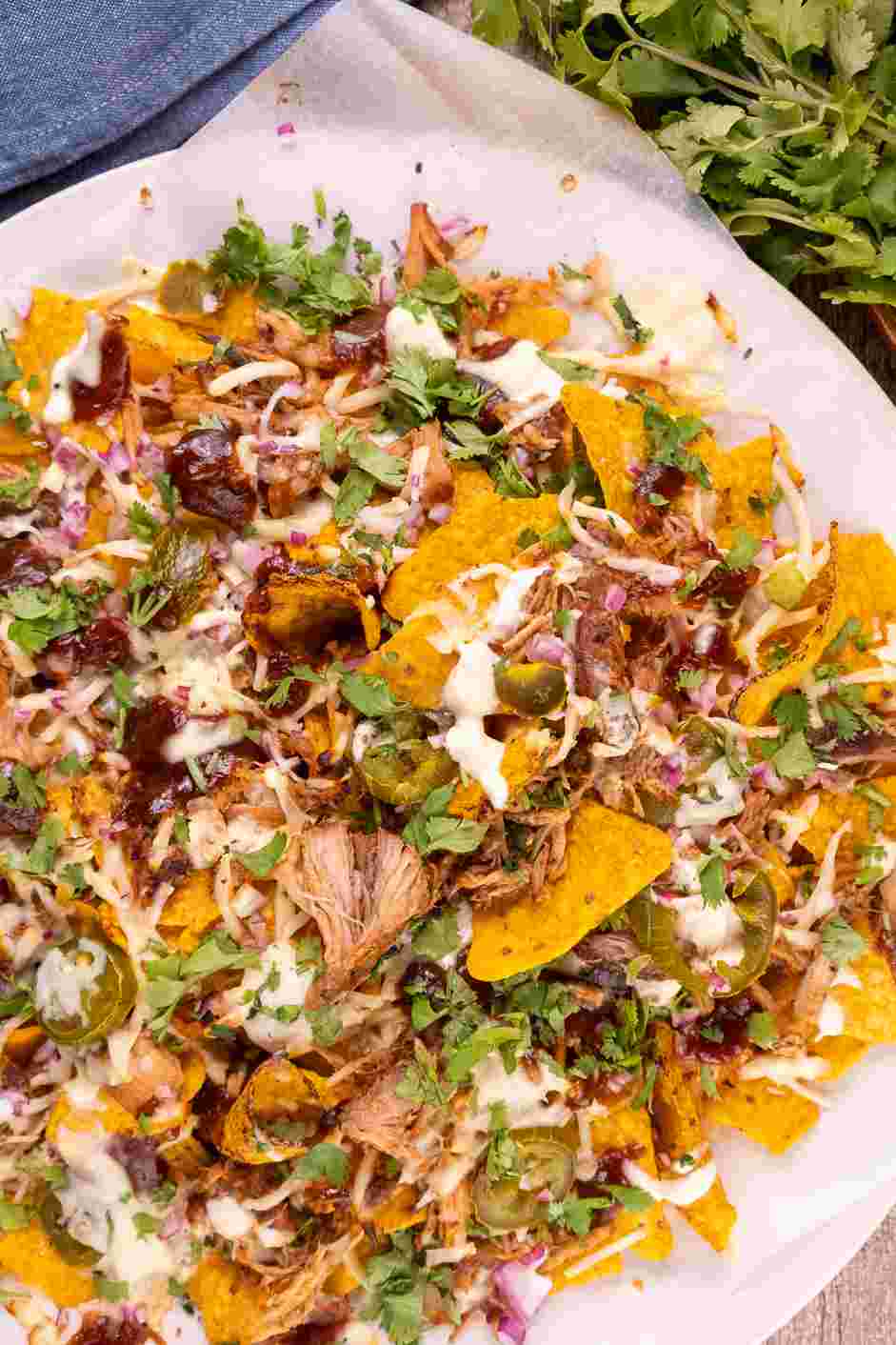 Pulled Pork Nachos Recipe: Top with sour cream and cilantro and serve.