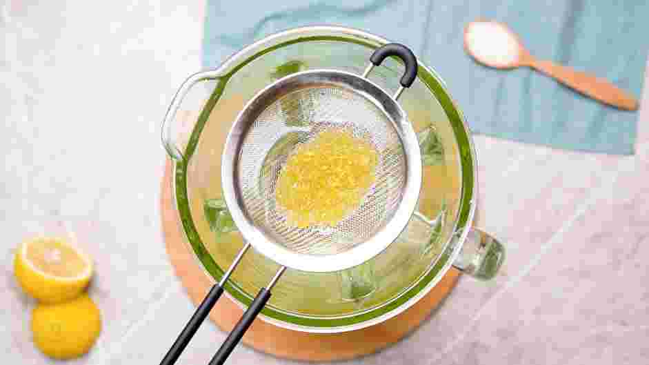 Frozen Lemonade Recipe: Use a fine-mesh strainer to strain the lemon simple syrup into the jar of a blender.