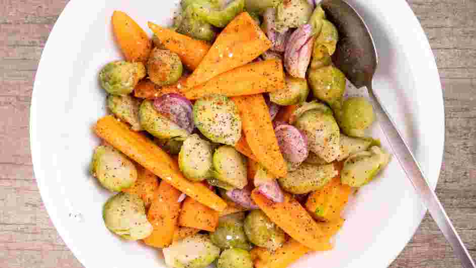 Spatchcock Chicken Recipe: In a large mixing bowl, place the halved Brussels sprouts, sliced red onion and baby carrots.