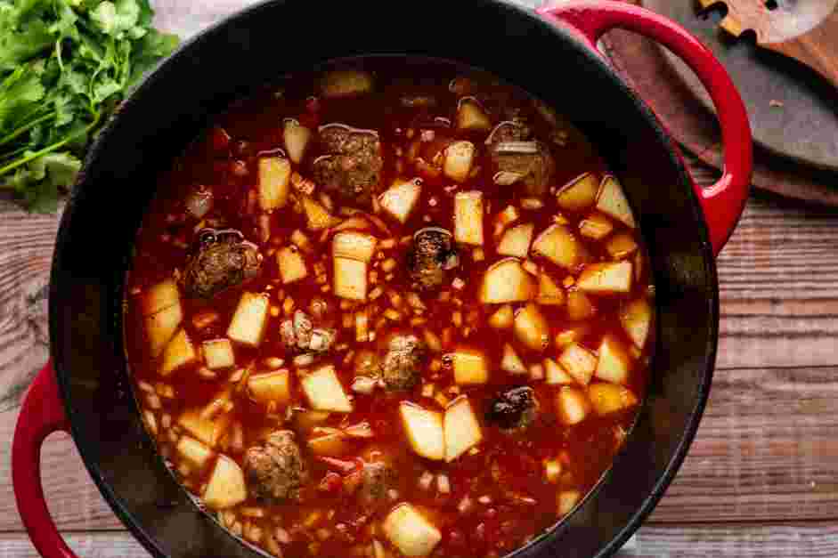 Mexican Meatball Soup (Albondigas) Recipe: Add the diced chayote squash, carrots, tomato, onion, garlic, chicken stock and cannellini beans to the stockpot.