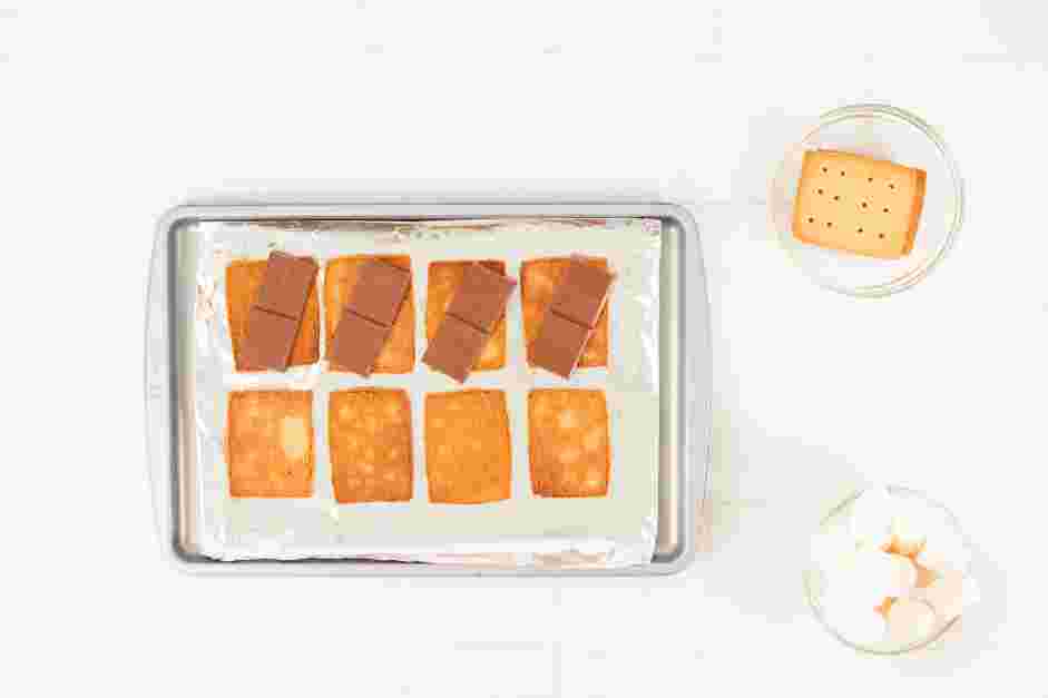 Smores in the Oven Recipe: Divide the chocolate bar into four equal portions and place one piece on each graham cracker.