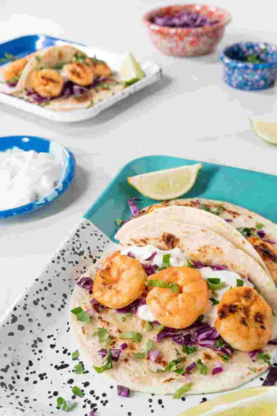 Grilled Shrimp Tacos Recipe: Serve with warmed corn tortillas, shredded cabbage, finely chopped cilantro, lime wedges and chipotle sour cream.