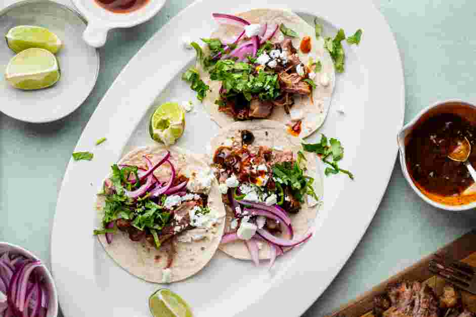 Brisket Tacos Recipe: Lay the tortilla on a flat surface and add the brisket, onion, cilantro, jalape&ntilde;o and cheese.