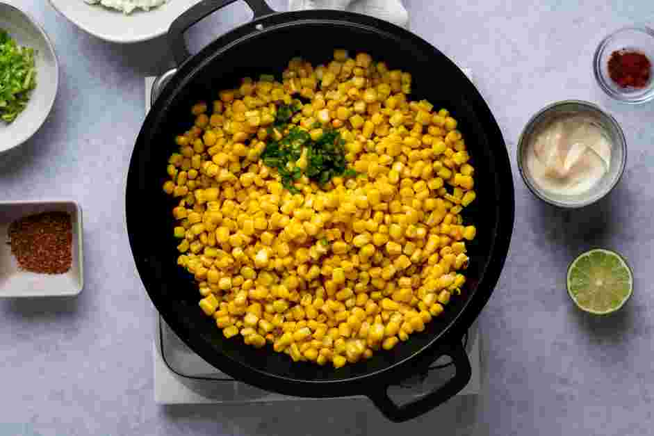 Street Corn Dip Recipe: Once the butter is melted add the corn kernels and the jalapeno pepper to the skillet and spread in an even layer.