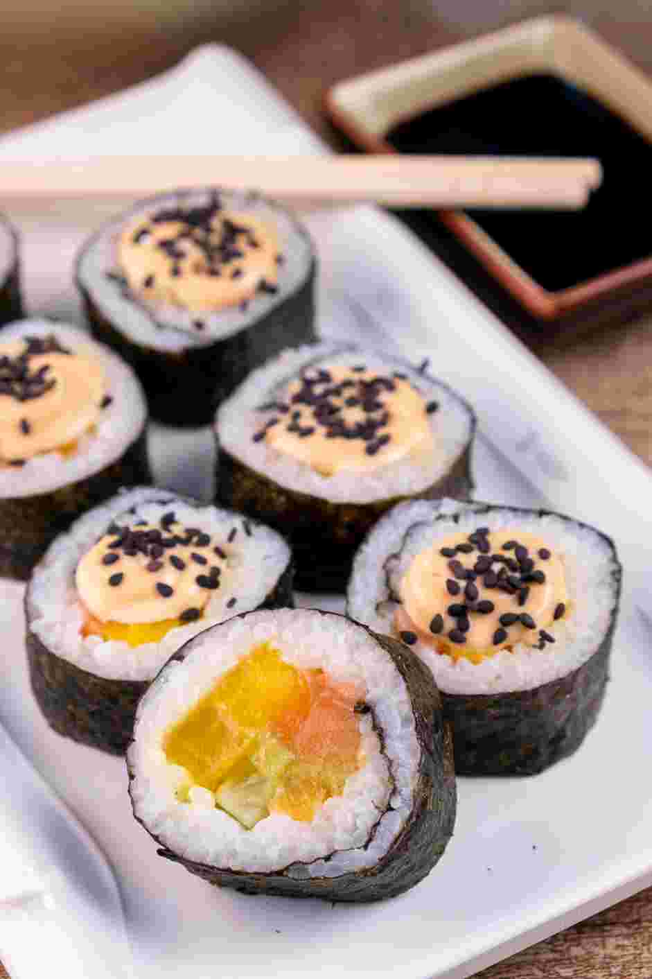 Crunch Roll Sushi Recipe: Drizzle the spicy mayo on top of each piece and garnish with black sesame seeds.