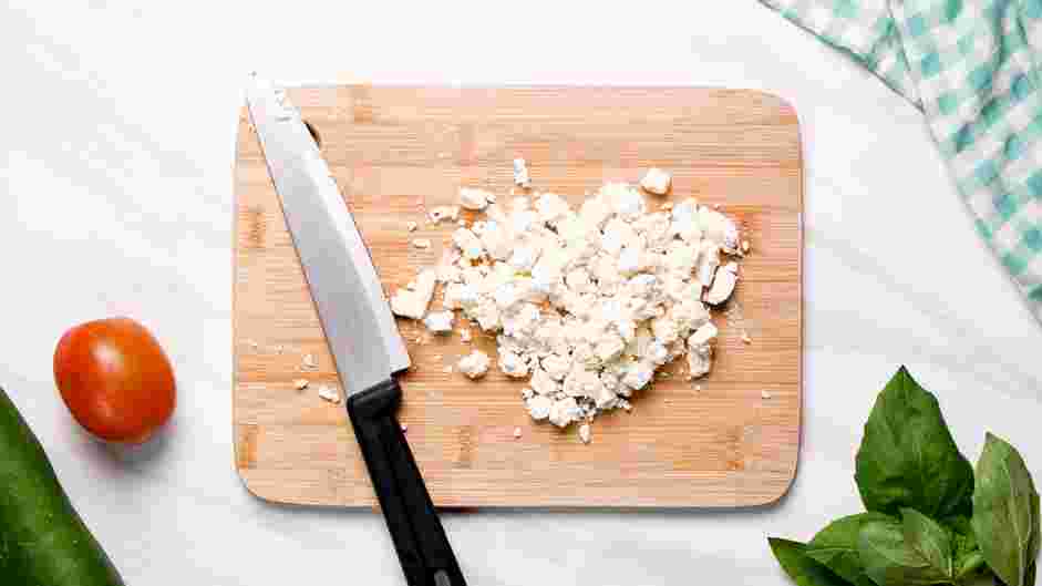 Cucumber Tomato Feta Salad Recipe: Dice or crumble the feta cheese and add to the bowl of tomatoes and cucumber.