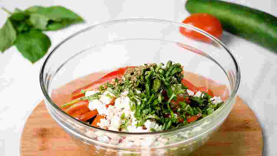 Cucumber Tomato Feta Salad Recipe: Add the basil and oregano to the bowl.