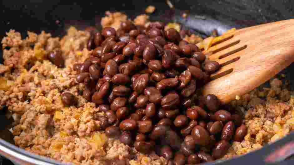 Totchos Recipe: Add the rinsed and drained beans, smoked paprika, salt and pepper to the skillet.