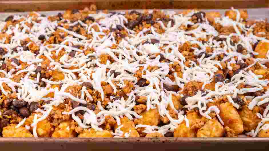 Totchos Recipe: Sprinkle the shredded cheese over the chorizo bean mixture.